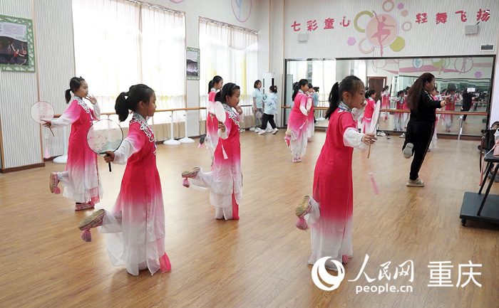 兩江云頂小學(xué)地川劇社團(tuán)延時(shí)課堂上，前北碚川劇團(tuán)演員周潔指導(dǎo)學(xué)生川劇。