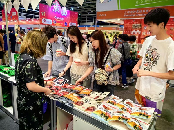 市民在重慶展位處品重慶美食。受訪單位供圖