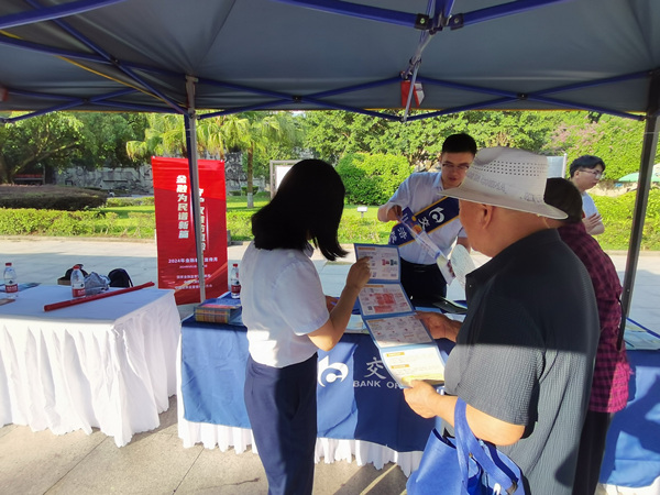 工作人員向市民發(fā)放宣傳資料，宣講金融知識。交行重慶市分行供圖