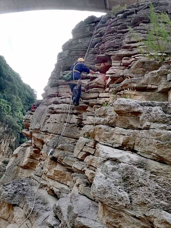 《為地災(zāi)防治事業(yè)練成飛檐走壁》。2023年8月，涪陵區(qū)烏江巖體劣化調(diào)查項(xiàng)目中，南江地質(zhì)隊(duì)高空作業(yè)人員正在懸崖壁上建設(shè)測窗監(jiān)測點(diǎn)。向棋攝
