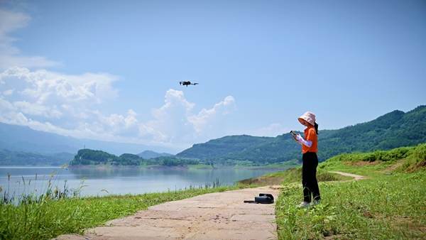《巾幗有擔(dān)當(dāng)》。8月6日，107地質(zhì)隊(duì)地質(zhì)工程師劉爽在萬(wàn)州區(qū)武陵鎮(zhèn)江灣區(qū)域開(kāi)展無(wú)人機(jī)航拍工作。傅林?jǐn)z