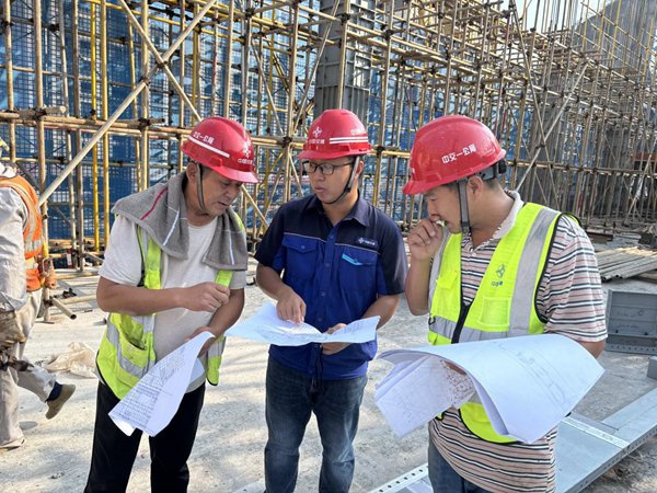 在萬州上海醫(yī)院新院區(qū)施工現(xiàn)場(chǎng)，施工人員在認(rèn)真討論。中交一公局三公司供圖