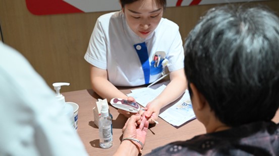 護士為老年患者測血糖。重慶南坪愛爾眼科醫(yī)院供圖
