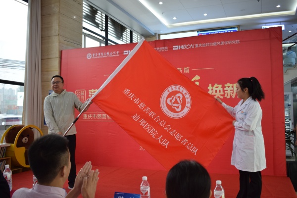 翁順春為迪邦醫(yī)院志愿者大隊授旗。重慶迪邦皮膚病醫(yī)院供圖