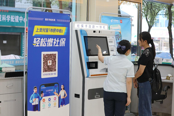 在秀山縣郵政銀行城北分行，郵政人員正為市民講解社保業(yè)務(wù)辦理和支付寶“重慶稅務(wù)”生活號(hào)繳費(fèi)流程。張雯惠攝