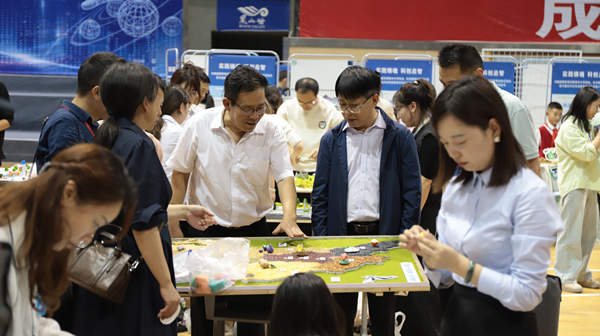展評(píng)活動(dòng)現(xiàn)場(chǎng)，嘉賓體驗(yàn)制作區(qū)域地圖。重慶市萬(wàn)盛經(jīng)開區(qū)教育局供圖