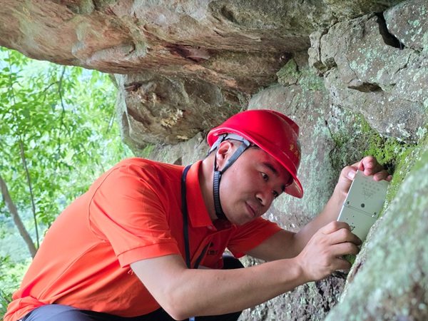 《專注》。7月3日，南江地質(zhì)隊地質(zhì)工程師陳昊在開州區(qū)麻柳鄉(xiāng)調(diào)查危巖。劉黎攝