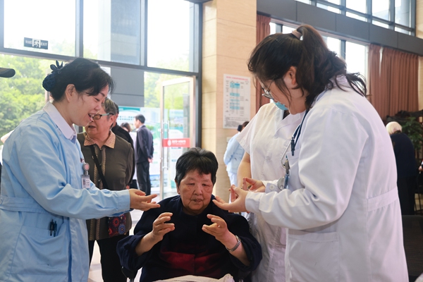 重慶市第十三人民醫(yī)院護(hù)師指導(dǎo)老年人進(jìn)行家庭康復(fù)訓(xùn)練。曾英豪攝