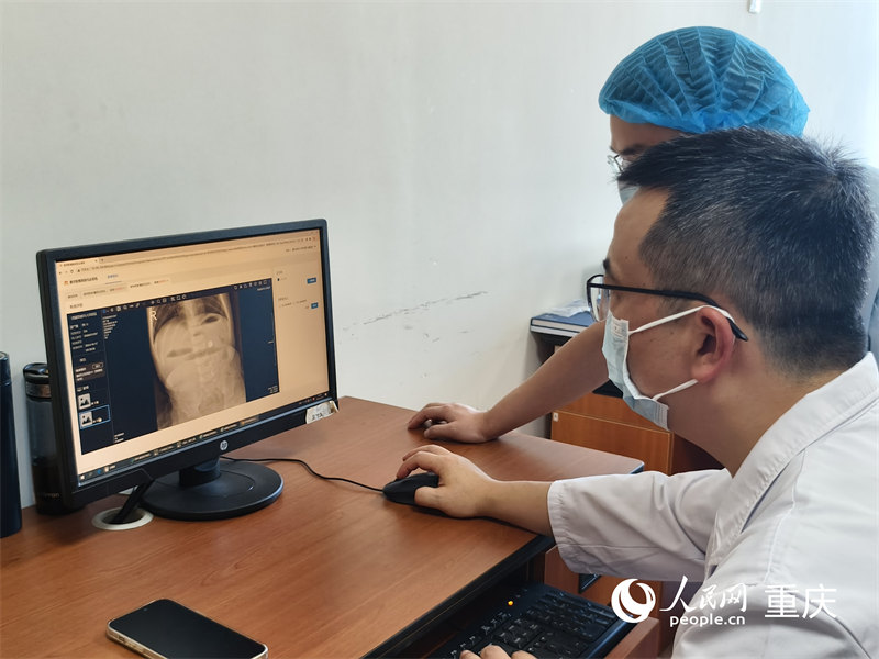 重慶醫(yī)科大學(xué)附屬兒童醫(yī)院兩江院區(qū)，醫(yī)生們通過醫(yī)檢互認(rèn)系統(tǒng)查看患兒在當(dāng)?shù)氐臋z查結(jié)果。人民網(wǎng) 陳琦攝