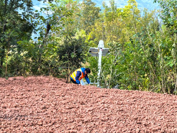 《巡查檢查監(jiān)測儀器（組圖）》。10月4日，王忠凌在日常巡查中，檢查地災(zāi)點的監(jiān)測儀器是否正常工作。只有做好了日常維護，才能確保告警的準(zhǔn)確度。劉勇攝
