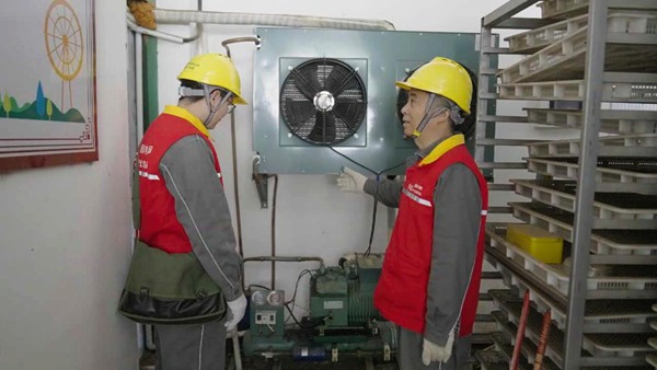 電力工人對烘干房用電設備進行安全檢查。國網(wǎng)重慶永川供電公司供圖