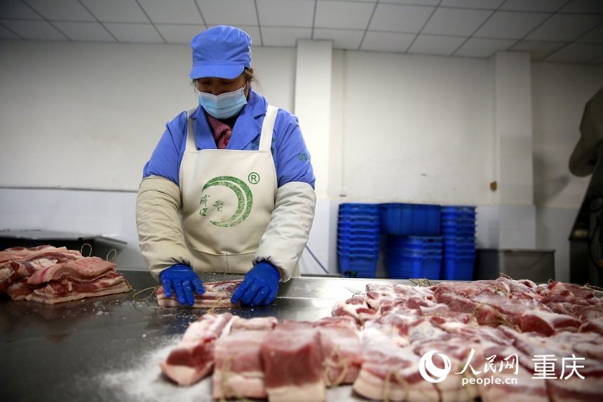 工人手工對分割好的豬肉進行碼鹽。人民網(wǎng)記者 劉政寧攝