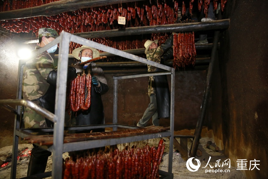 工作人將炕制好的臘味下架取出。人民網(wǎng)記者 劉政寧攝