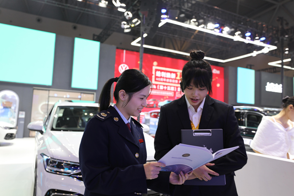 沙坪壩區(qū)稅務(wù)人員向汽車銷售企業(yè)宣傳消費(fèi)品以舊換新相關(guān)政策。郭亞玲攝