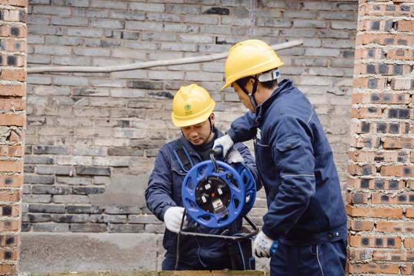 電力人員檢查供電線路并牽線入戶。國網(wǎng)重慶永川供電公司供圖