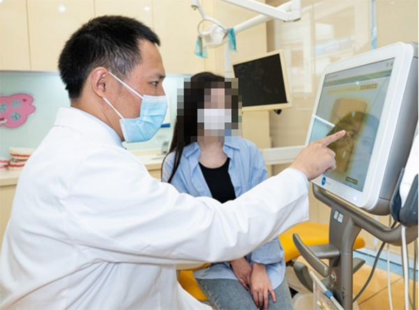 醫(yī)生為患者講解牙齒情況。泰康拜博口腔供圖