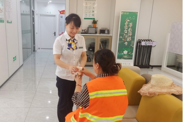 柜面工作人員為環(huán)衛(wèi)工人送清涼。中國人壽壽險重慶市分公司供圖