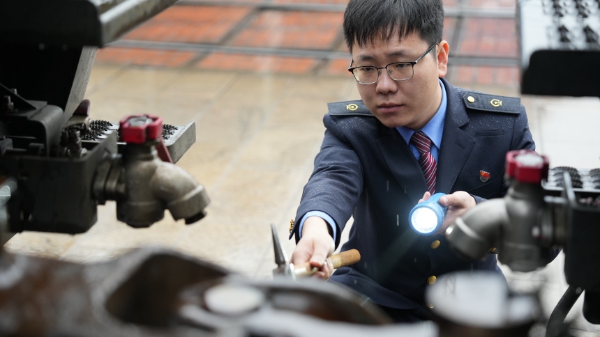 中歐班列發(fā)車前，謝嗣航正在對機(jī)車走行部關(guān)鍵部件進(jìn)行檢查。周彥超攝
