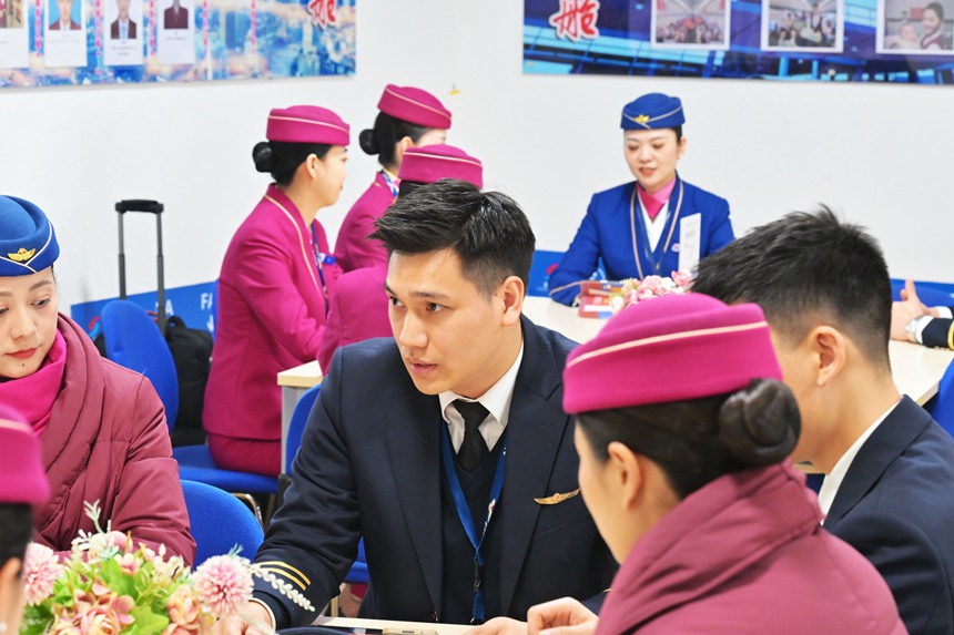 許航和楊曌分別與班組同事進行航前準備工作。鄒樂攝