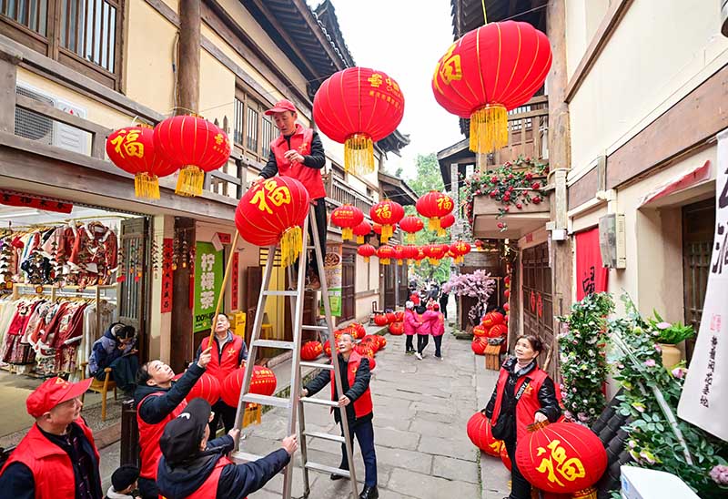 志愿者為黃葛古道敦厚坡老街的傳統(tǒng)民居掛燈籠。郭旭攝