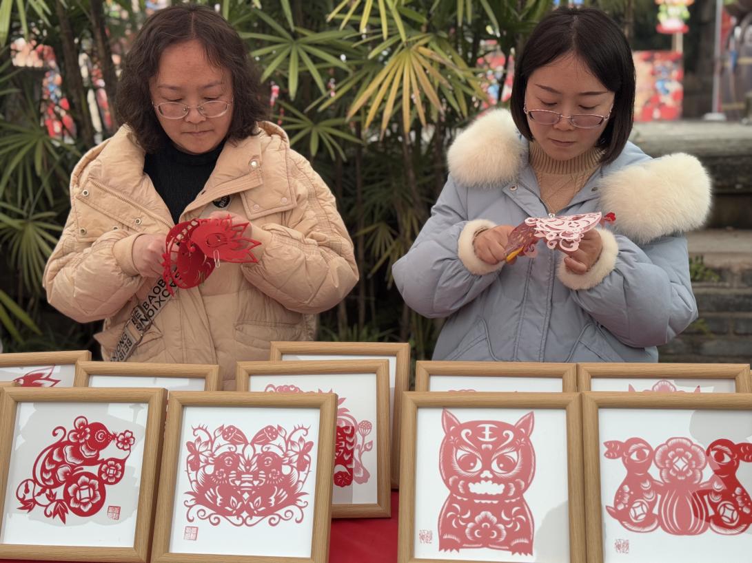 袁誼、趙俊教孩子們剪紙。黃亞輝攝