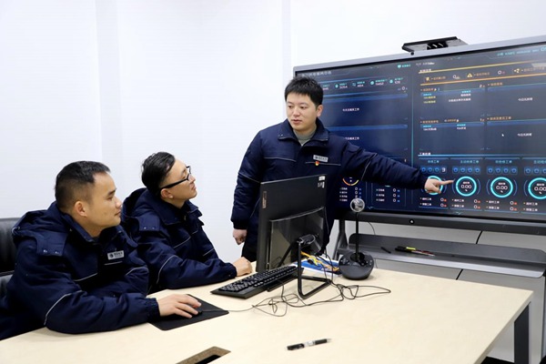 程政（右一）與同事研討電力大數(shù)據(jù)問題。國網(wǎng)永川供電公司供圖