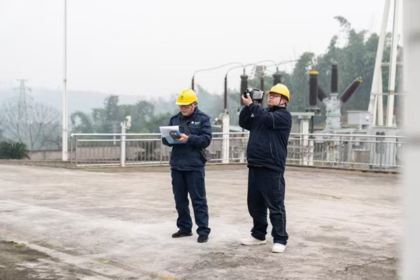 電力人員利用紅外測(cè)溫儀檢查設(shè)備運(yùn)行情況。國(guó)網(wǎng)重慶永川供電公司供圖