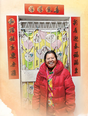 貼好春聯(lián)，彭其碧笑意盈盈。陳翔攝