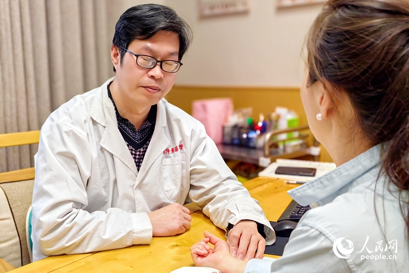 中醫(yī)館里，一名中醫(yī)正在把脈問診。人民網(wǎng) 程明輝攝