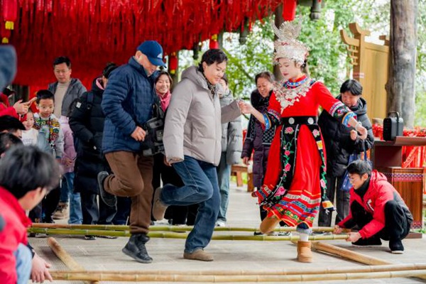游客與嬌阿依歡跳竹竿舞。景區(qū)供圖