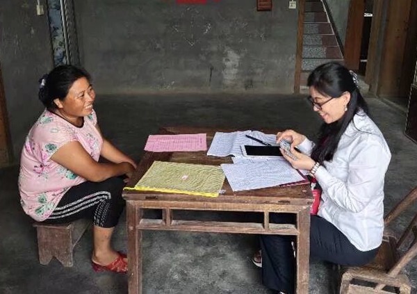 圖為冉力（右）走訪農(nóng)戶，筆記本上記滿民情，心中裝著萬家燈火。重慶移動供圖