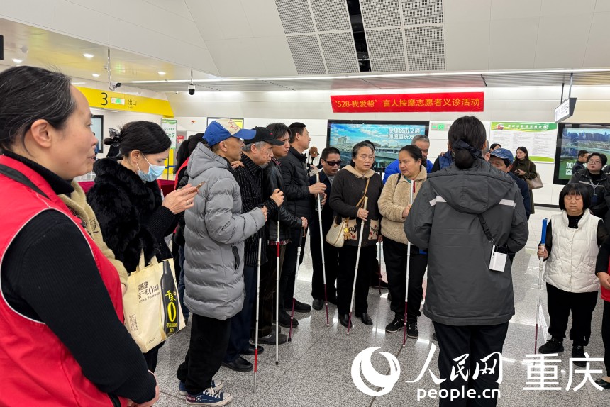 現(xiàn)場(chǎng)軌道交通工作人員為盲人朋友介紹便利設(shè)施。人民網(wǎng)記者 胡虹攝