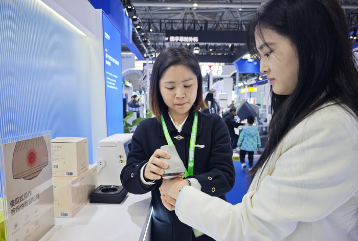 工作人員展示超聲波關(guān)節(jié)按摩儀。重慶海扶醫(yī)療供圖