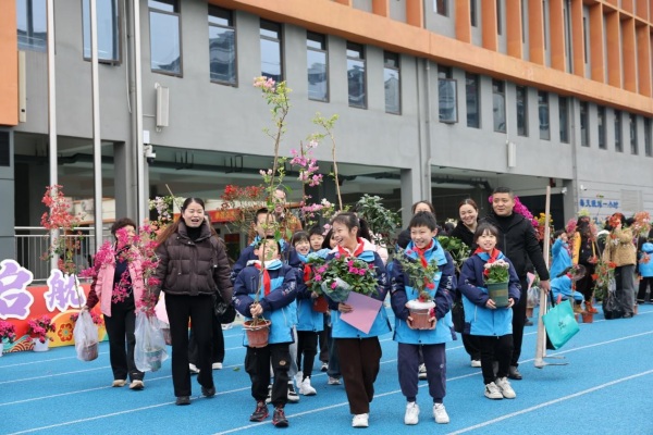 學(xué)生和家長歡歡喜喜“認(rèn)養(yǎng)”苗木。秦廷富攝