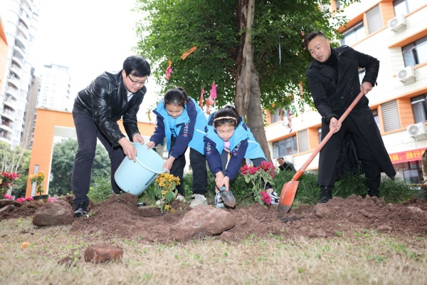 學(xué)生和老師、家長攜手植綠，共同美化校園。秦廷富攝