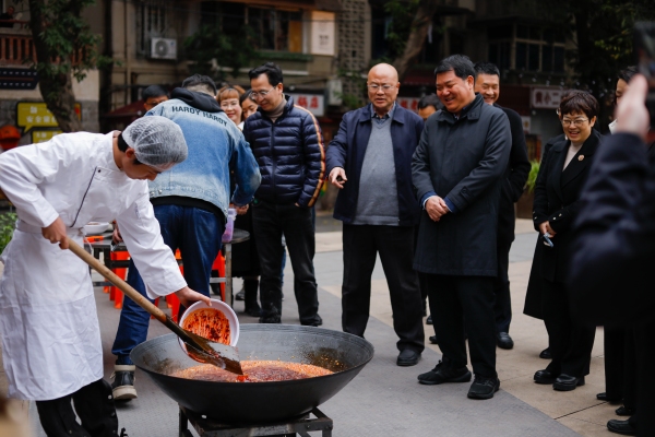 半坡聚落的火鍋店老板現(xiàn)場傳授火鍋炒料技巧。九龍坡區(qū)社區(qū)教育學(xué)院供圖