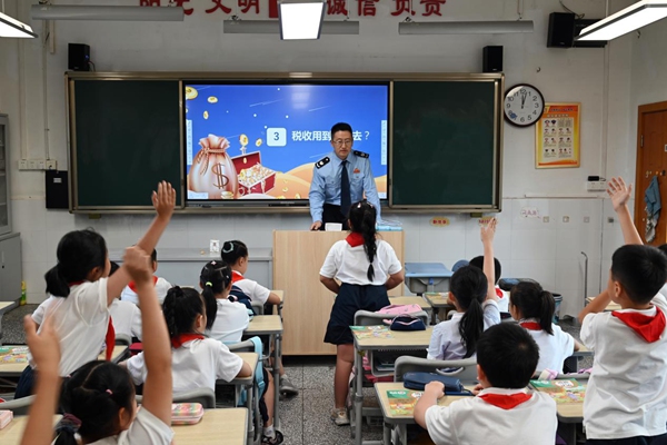 渝中區(qū)稅務人員走進馬家堡小學六年級6班，與同學們共上“稅法一堂課”，課堂上同學們踴躍舉手發(fā)言。徐佑君攝