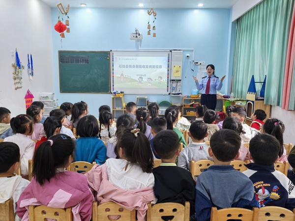 在石柱縣育之星幼兒園活動教室里，稅務人員播放稅收普法話劇《喜洋洋與灰太狼之稅收大作戰(zhàn)》，通過寓教于樂的形式為小朋友們闡釋稅收的含義。許園攝