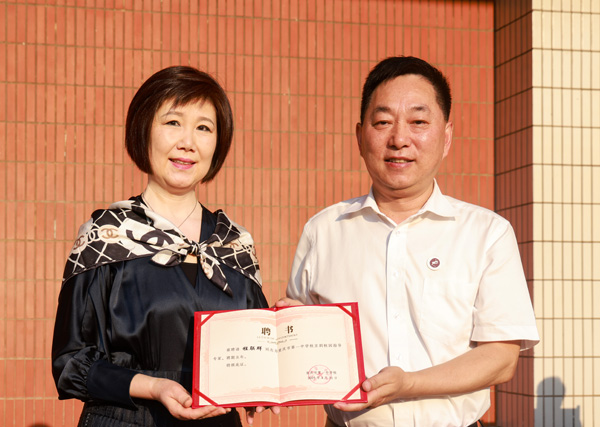 重慶一中黨委書記唐宏宇為程聯(lián)群頒發(fā)聘書。曾英豪攝