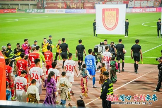 銅梁龍隊(duì)員與昌都孩子攜手入場(chǎng)。重慶銅梁龍足球俱樂部供圖