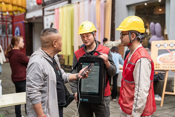 電力志愿者利用移動充電包為游客提供免費充電服務(wù)。賴小龍攝