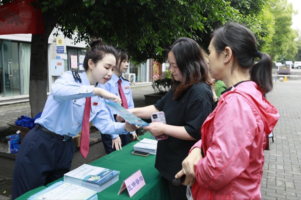 在南岸區(qū)雞冠石鎮(zhèn)石門社區(qū)，稅務(wù)部門設(shè)置稅費宣傳咨詢服務(wù)臺，向居民發(fā)放宣傳手冊，解答涉稅疑難問題。蔣宜非攝