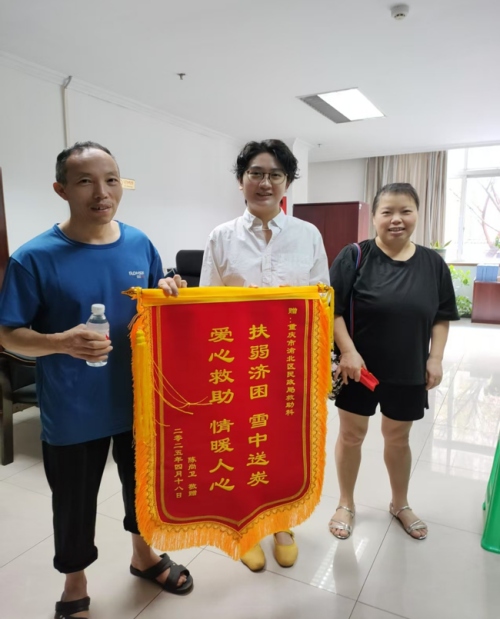 陳尚衛(wèi)為渝北區(qū)民政局救助科工作人員送上錦旗。渝北區(qū)民政局供圖