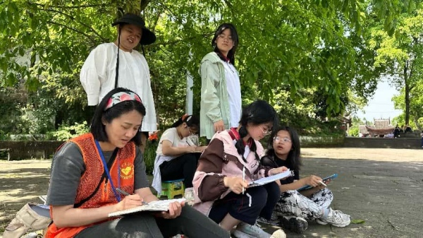 志愿者帶領游客親手描繪石刻。大足石刻研究院供圖