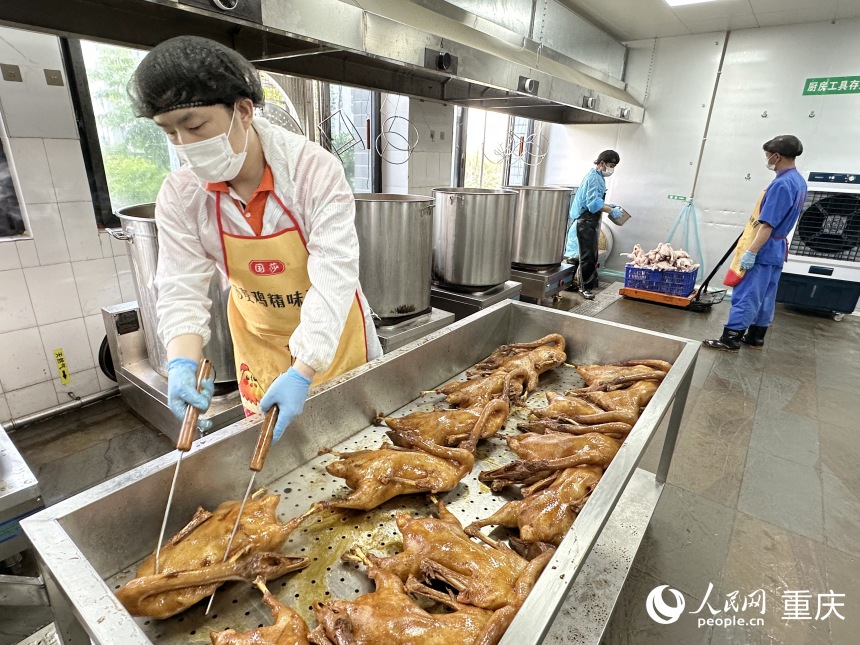 “鵝嫂”鹵鵝生產(chǎn)車間，工人將鹵制好的鹵鵝從鍋中取出冷卻。人民網(wǎng)記者 劉政寧攝