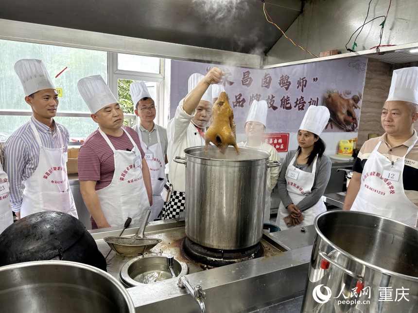 唐春暉（右三）和培訓(xùn)班學(xué)員學(xué)習(xí)傳統(tǒng)鹵鵝制作技藝。人民網(wǎng)記者 劉政寧攝