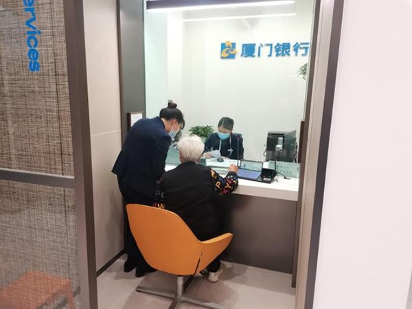 工作人員引導(dǎo)老年群體辦理相關(guān)業(yè)務(wù)。廈門銀行重慶分行供圖