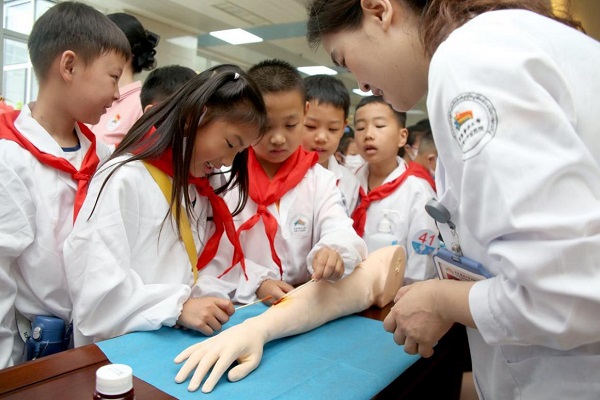 往屆活動中，小醫(yī)生們在醫(yī)護人員的指導下學習傷口消毒及包扎。重醫(yī)附屬大學城醫(yī)院供圖