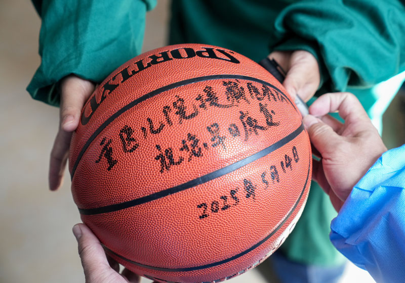 手術后，醫(yī)生為洛桑羅布送上籃球。 重慶醫(yī)科大學附屬兒童醫(yī)院供圖