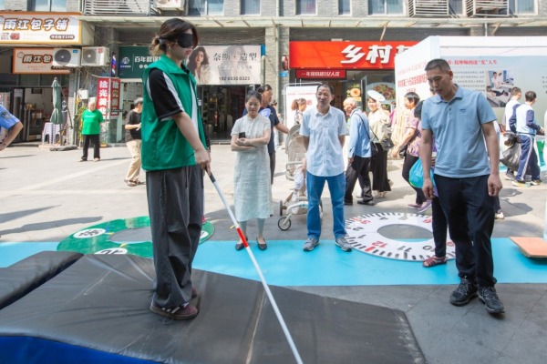 市民戴眼罩沉浸式體驗盲人行走。渝北殘聯(lián)供圖